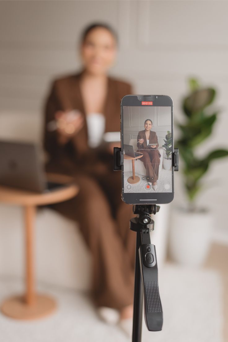 Celular em tripé gravando uma profissional durante a captação de conteúdo